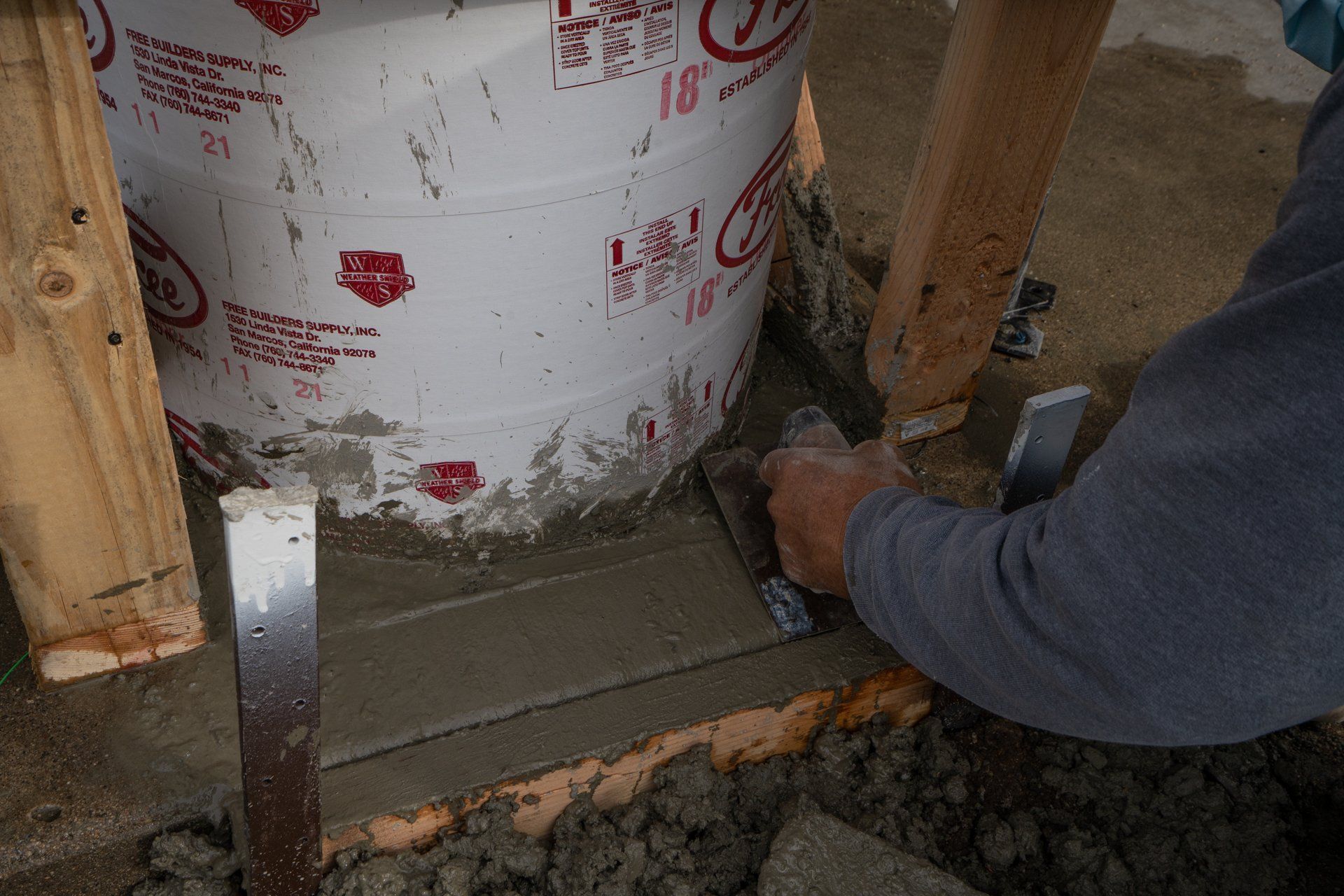 A person is cutting a piece of concrete with a saw.