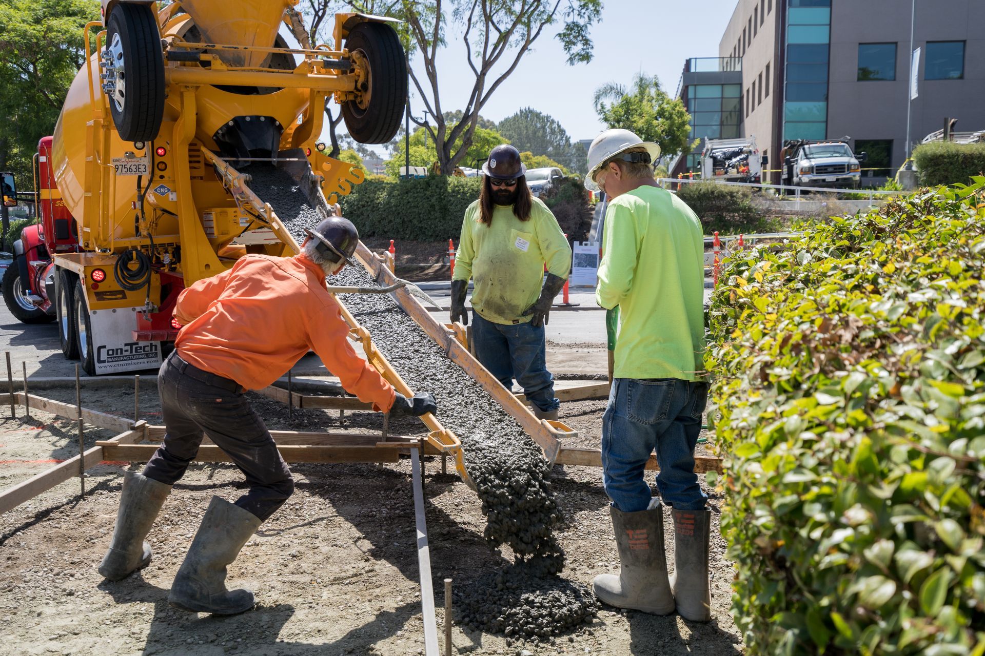 A group of construction workers are pouring concrete on a construction site.