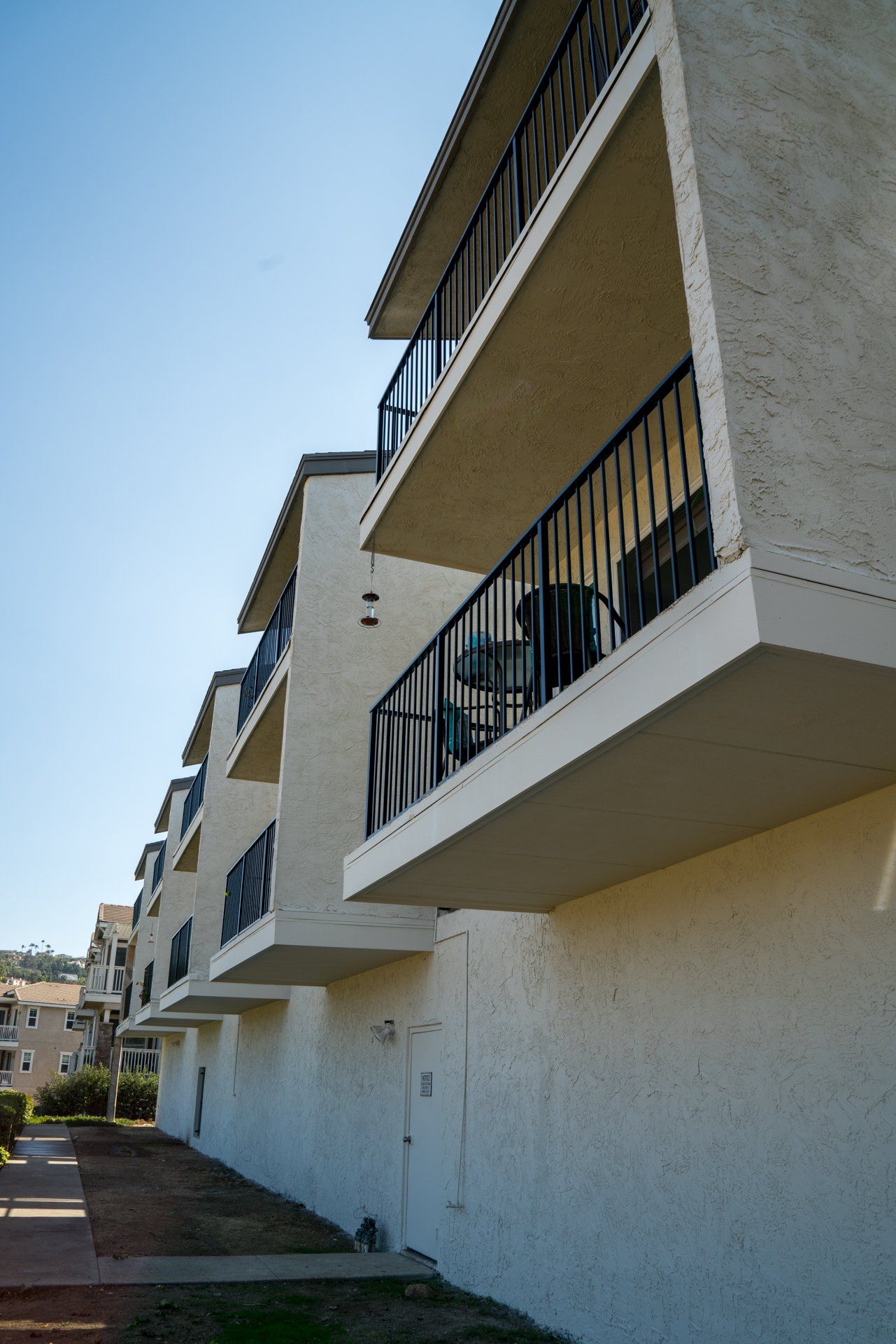 A row of white apartment buildings with balconies