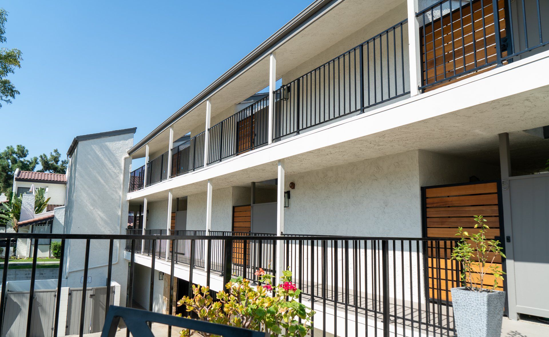 A white building with a balcony and a black railing