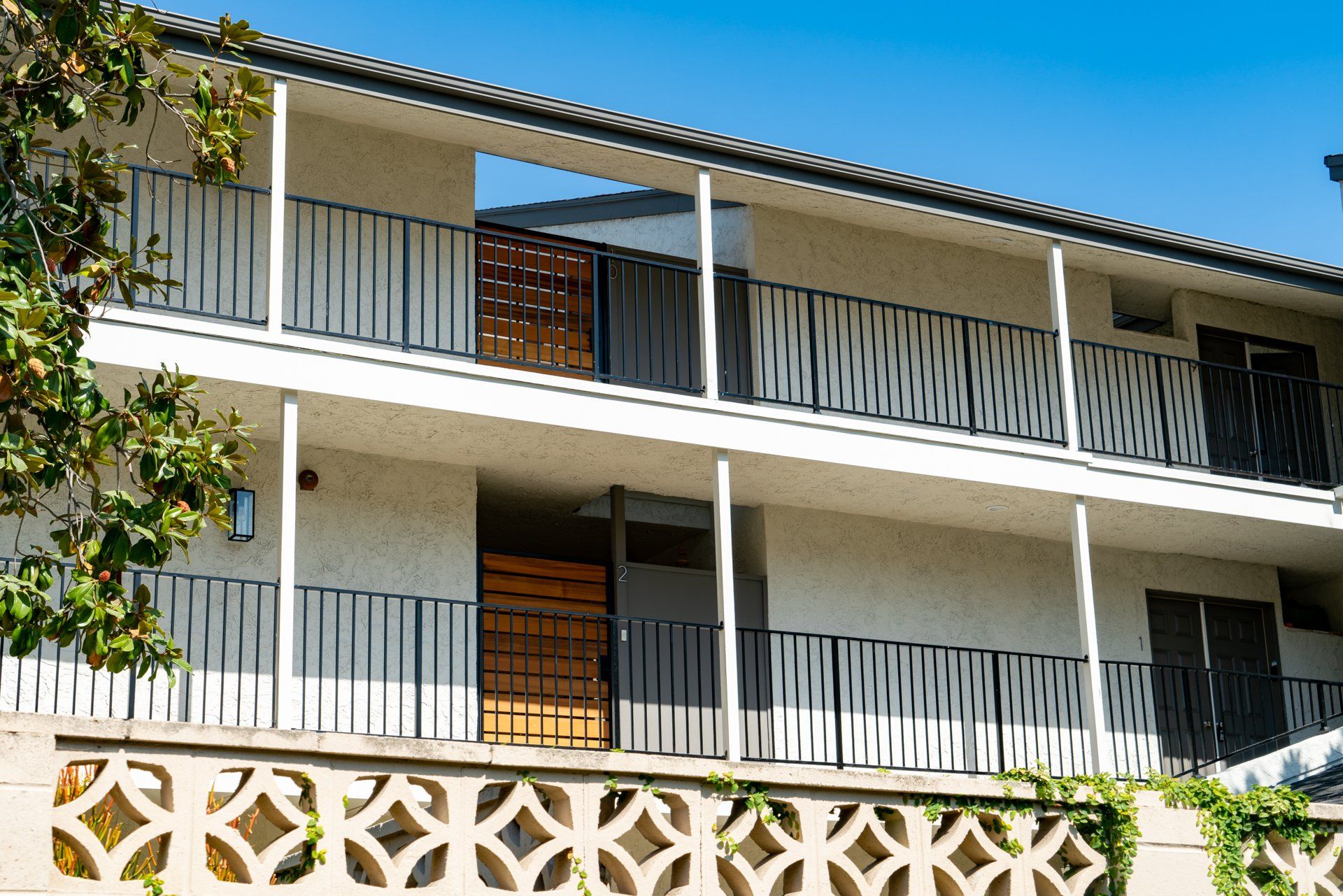 A building with a balcony and a tree in front of it