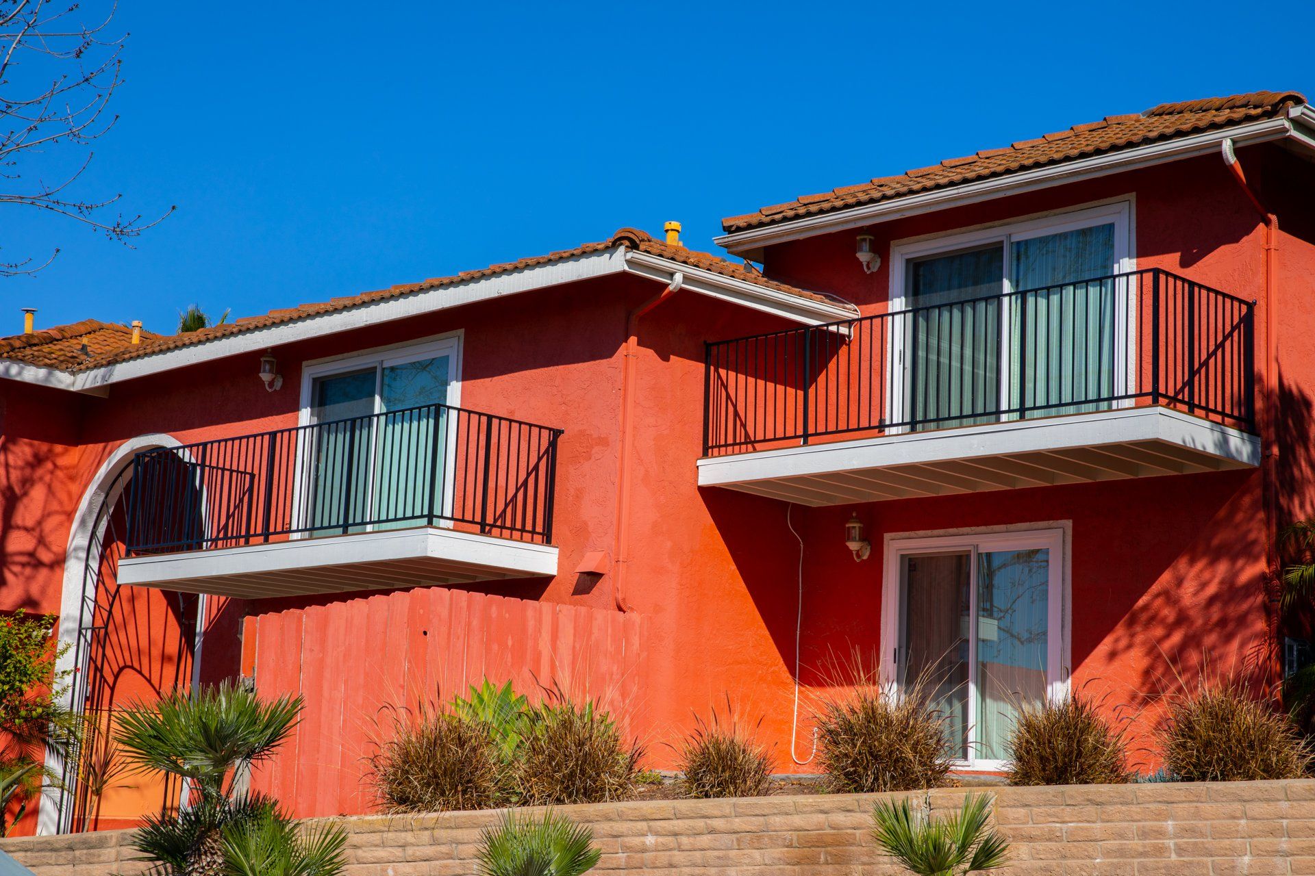 A red house with a balcony on the second floor