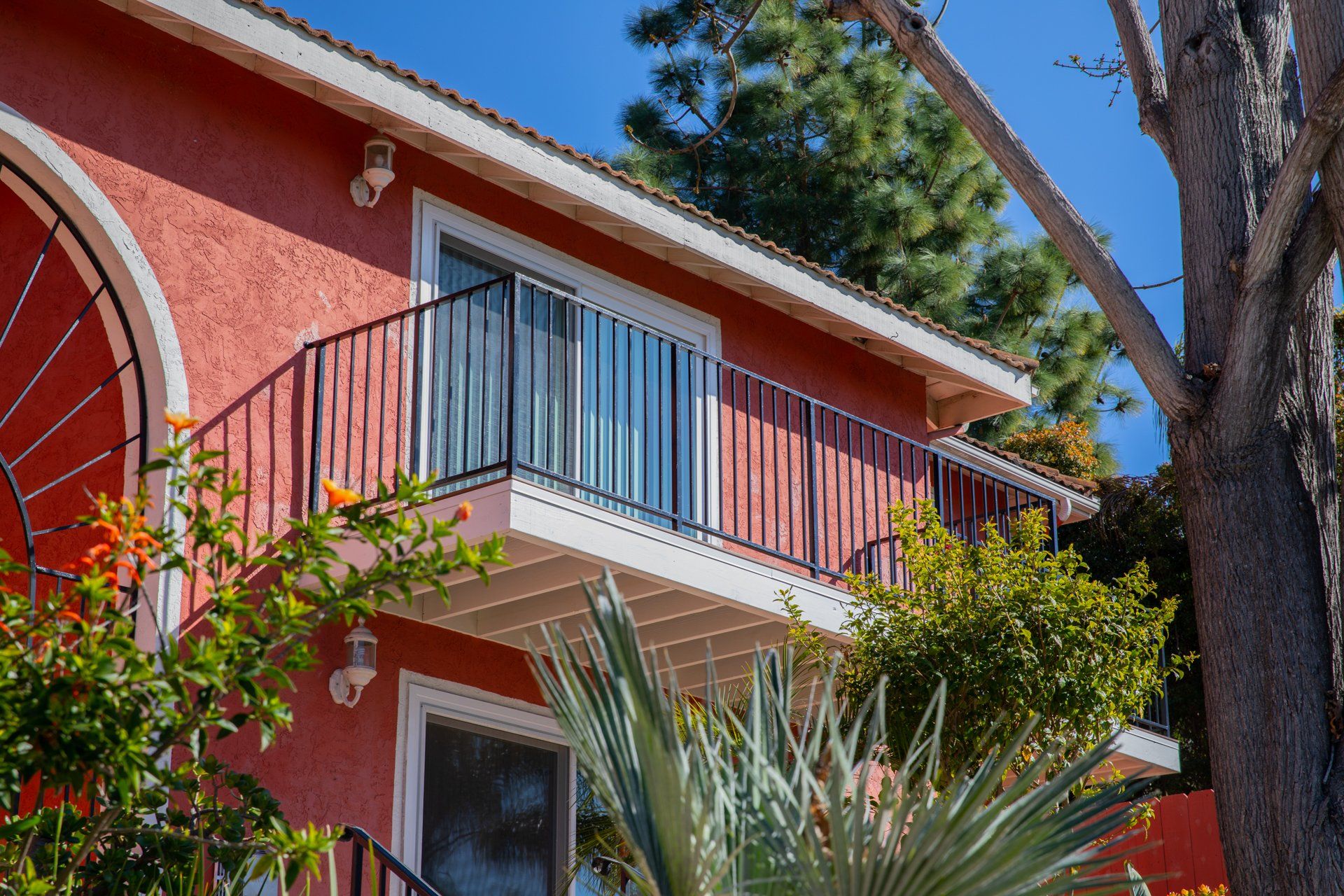A red house with a balcony on the second floor