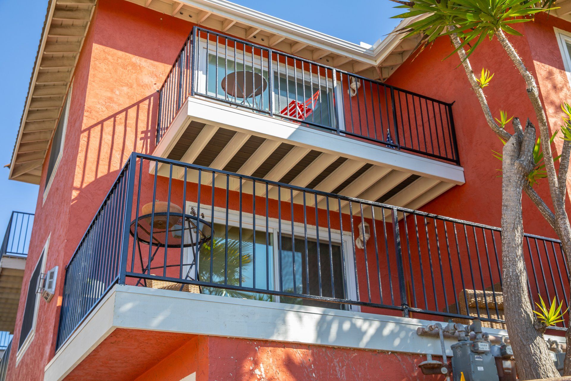 An orange building with a balcony and a black railing