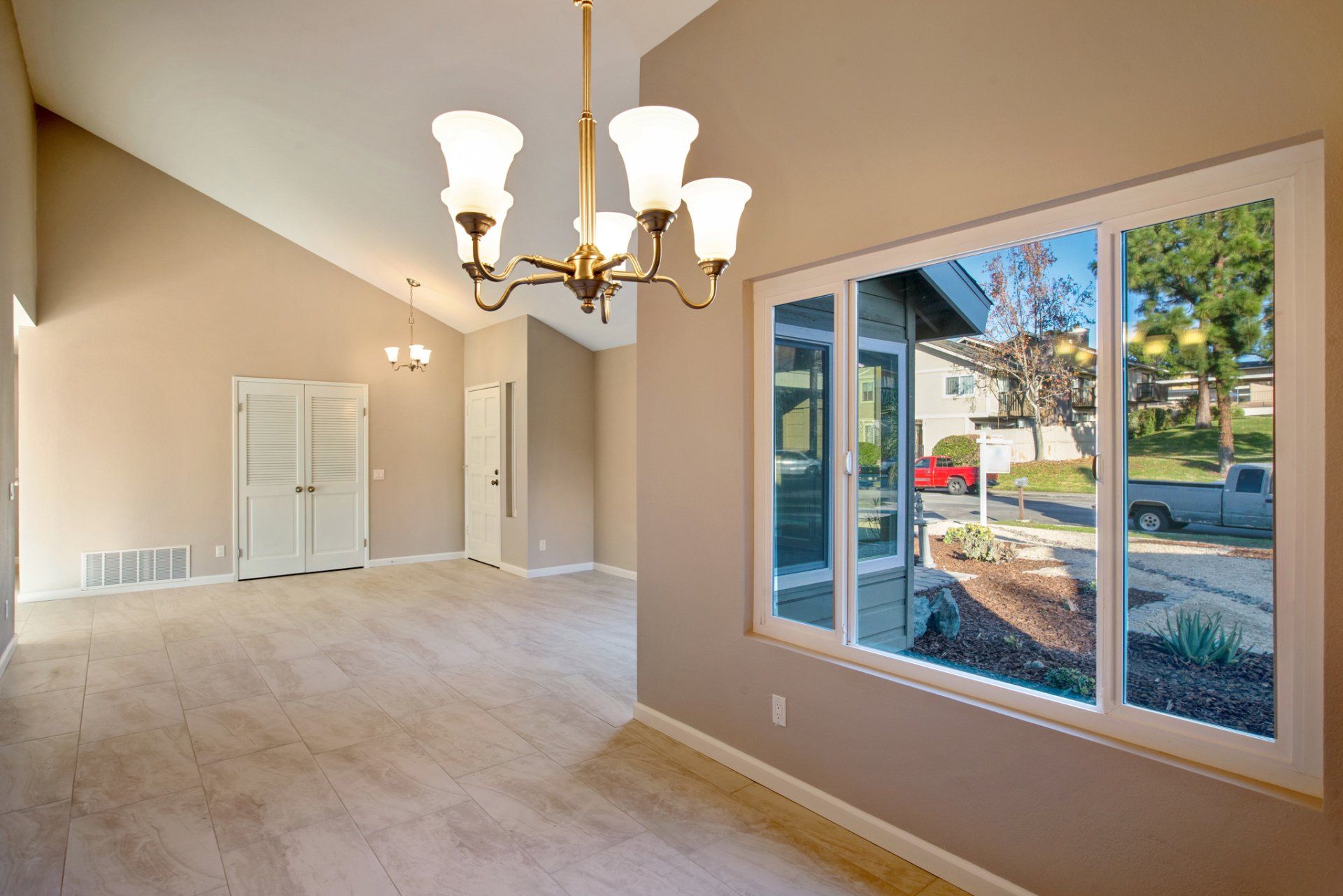 An empty room with a chandelier and a large window