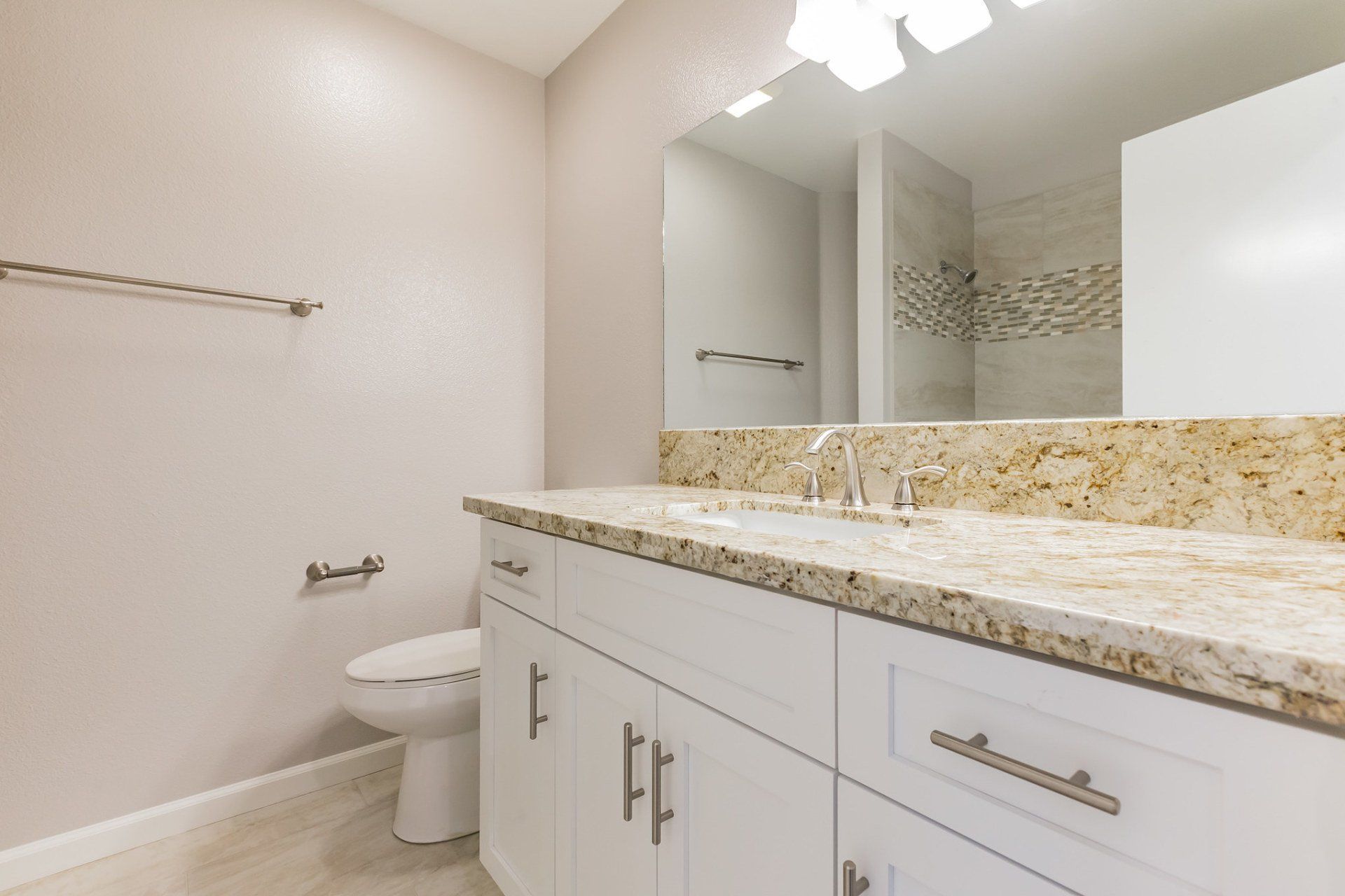 A bathroom with a toilet a sink and a mirror