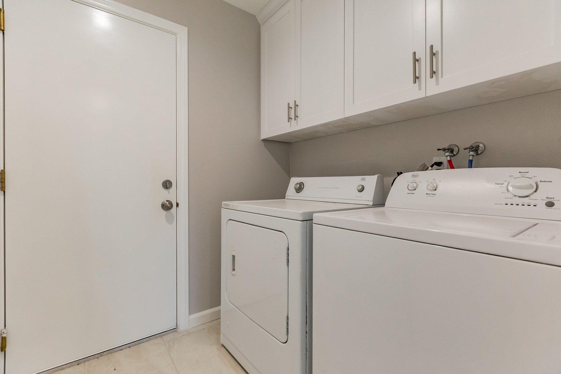 A laundry room with a washer and dryer and a door