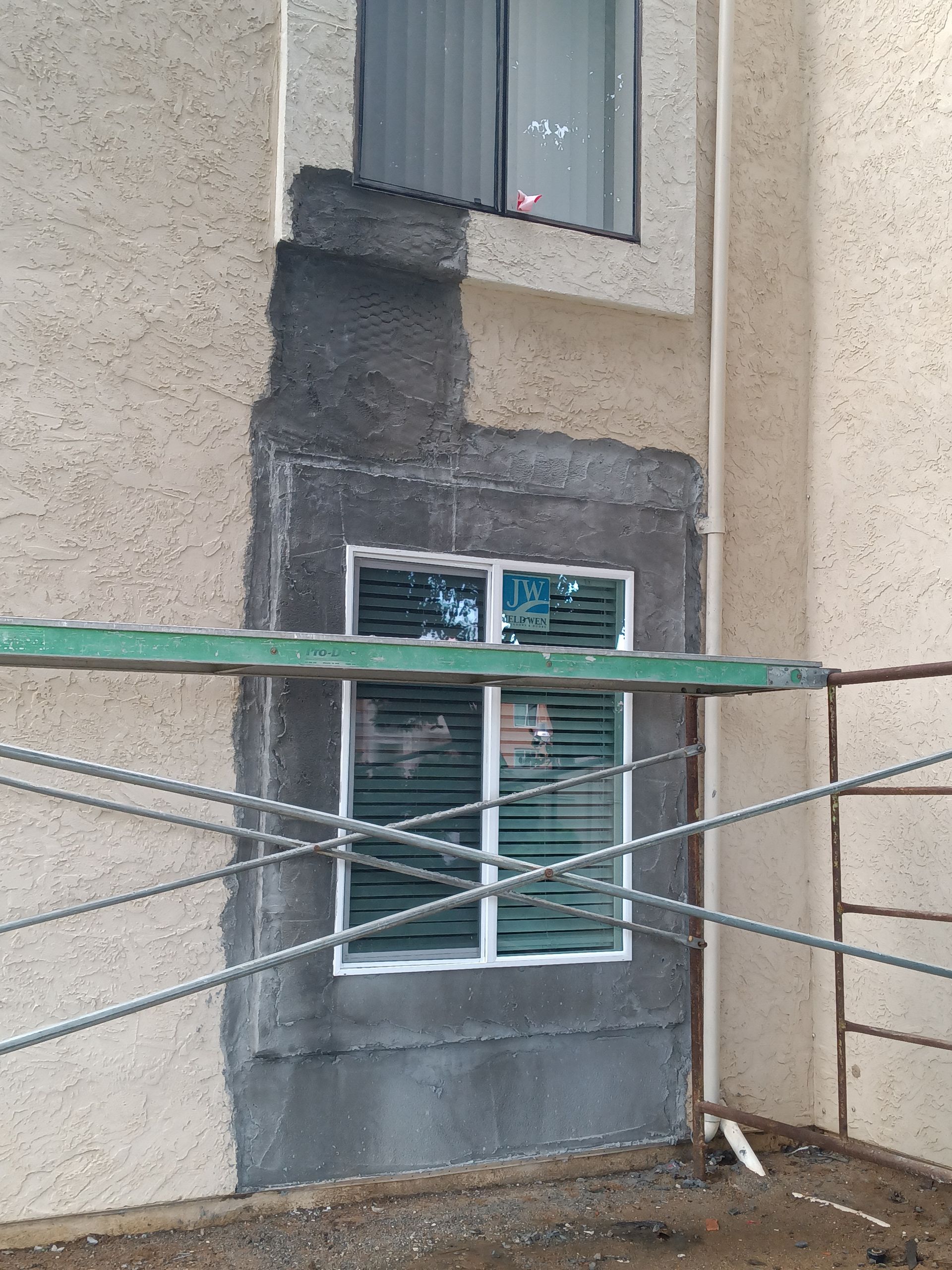 A window is being painted on the side of a building.