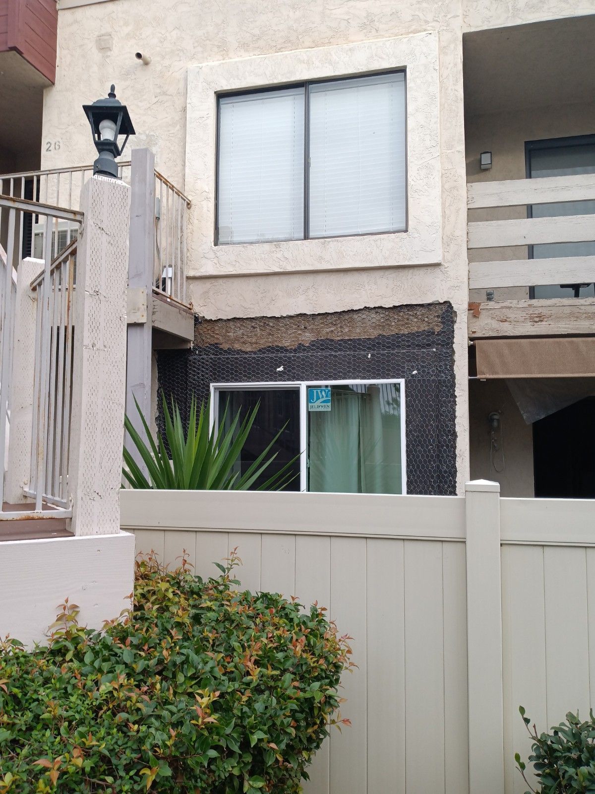 A white fence surrounds a building with a window