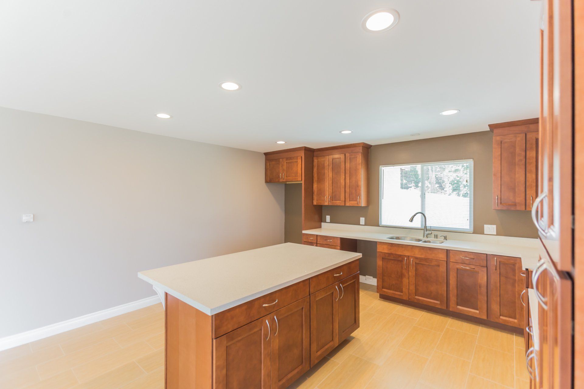 An empty kitchen with a large island in the middle