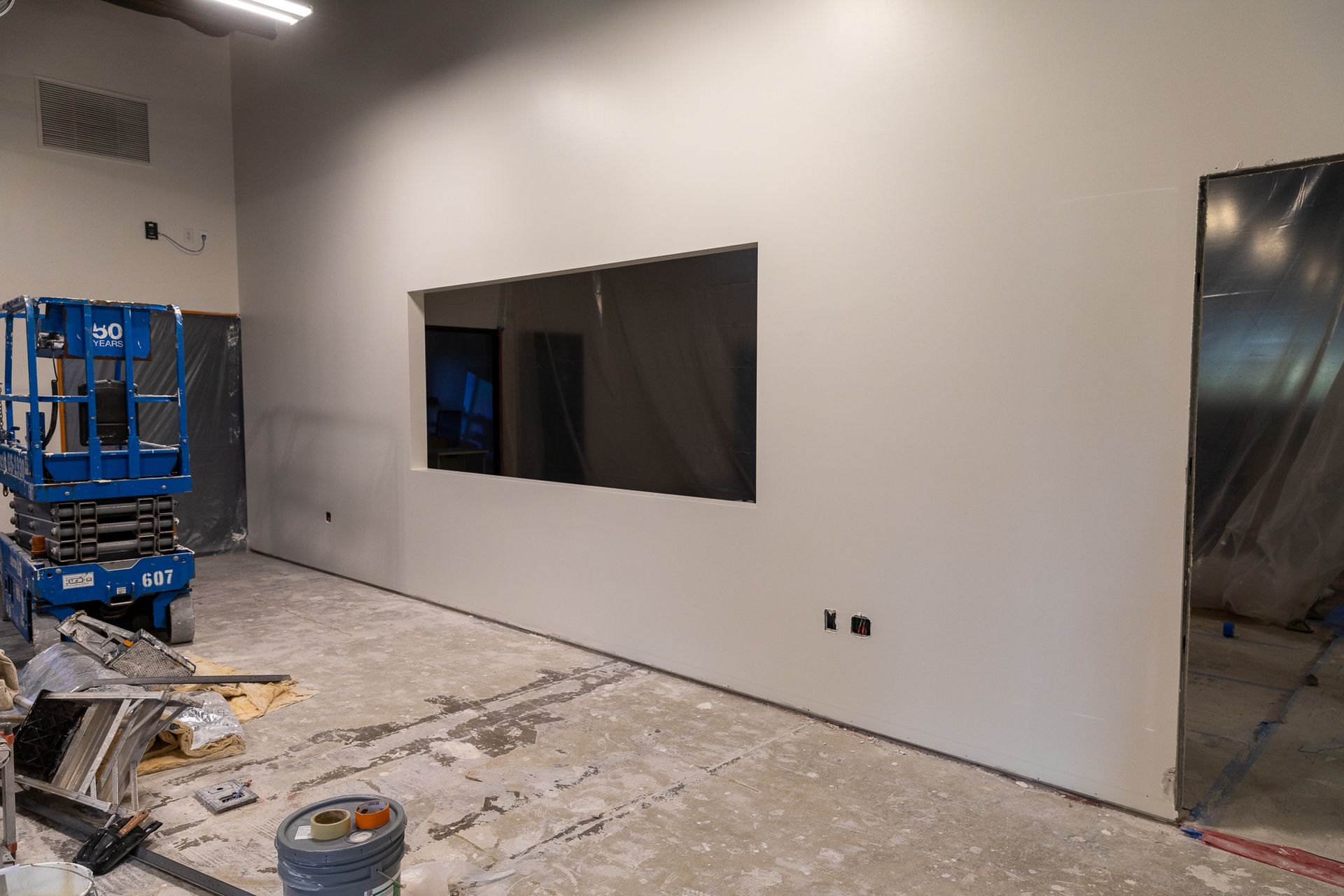 A room under construction with a window and a lift.