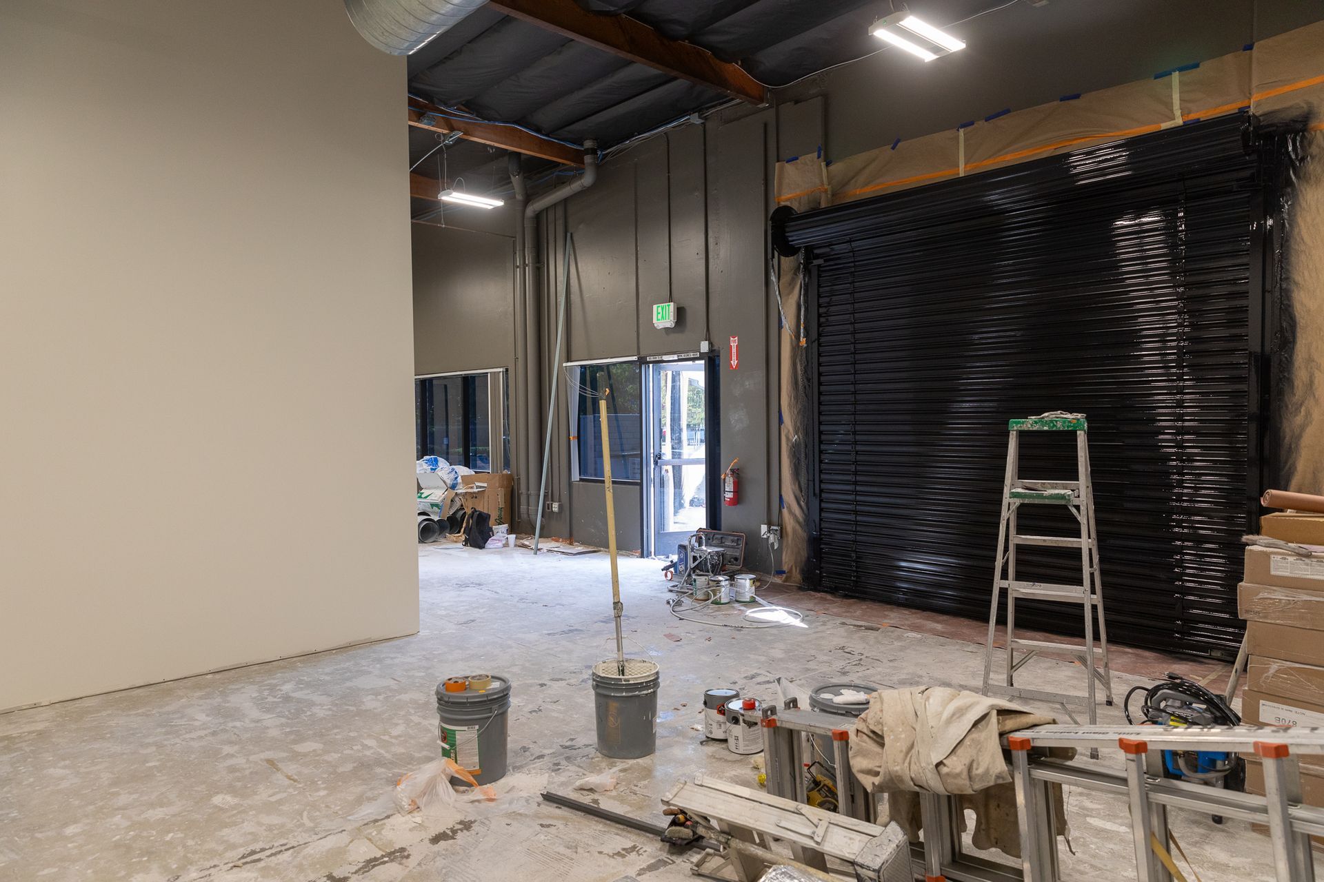 An empty room with a ladder and a mop in it.