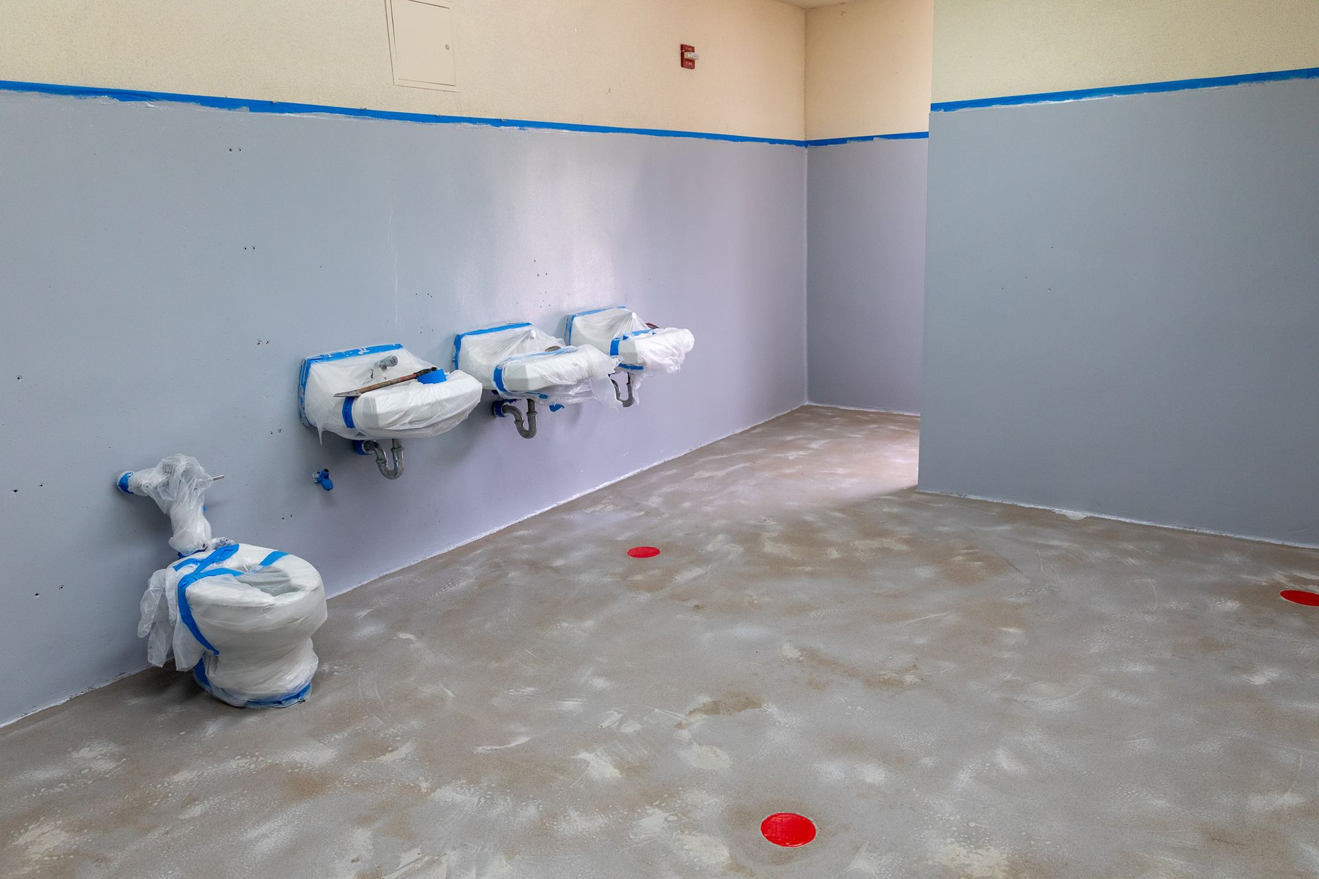 A bathroom with a toilet and sinks in it