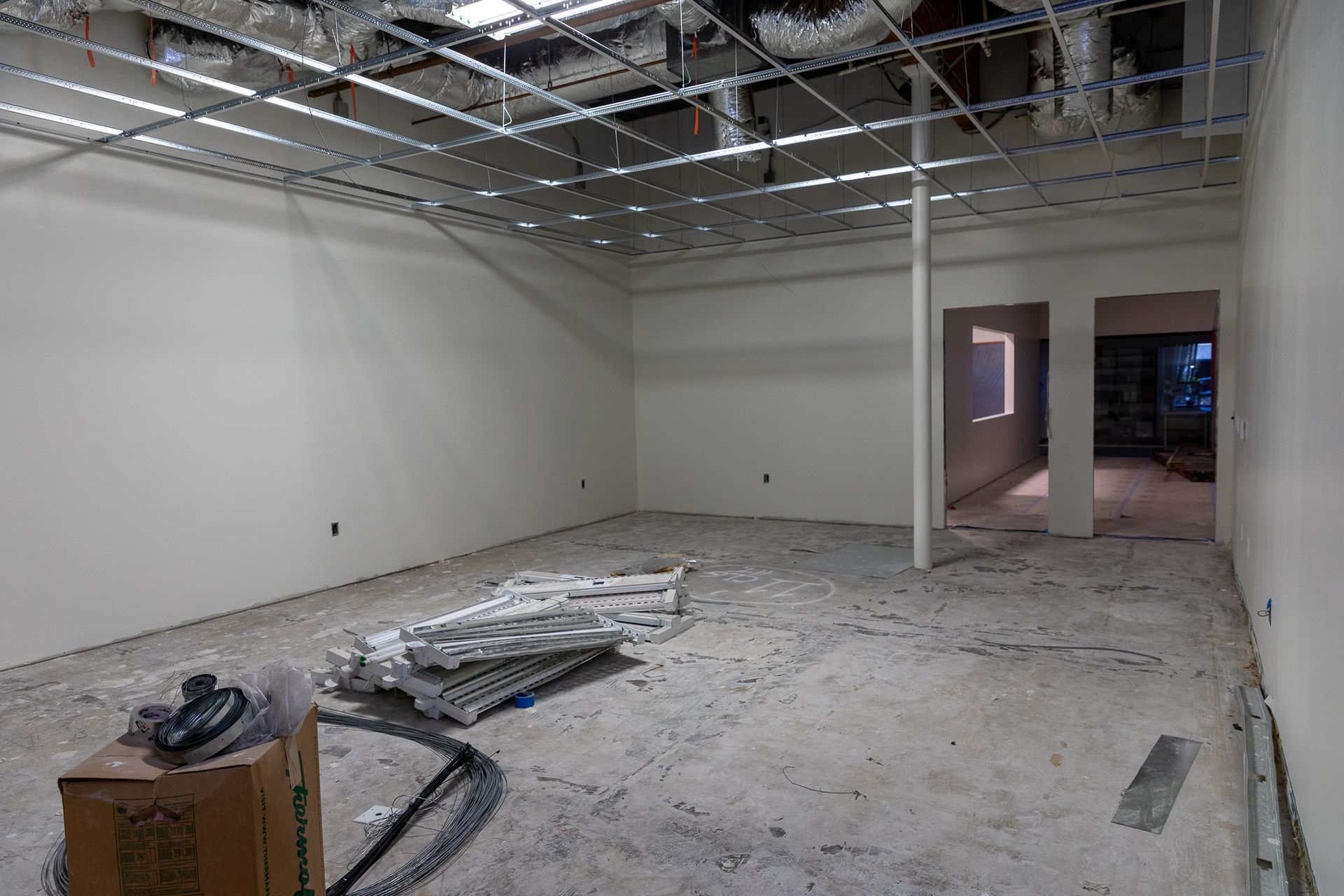 An empty room with white walls and a box on the floor.