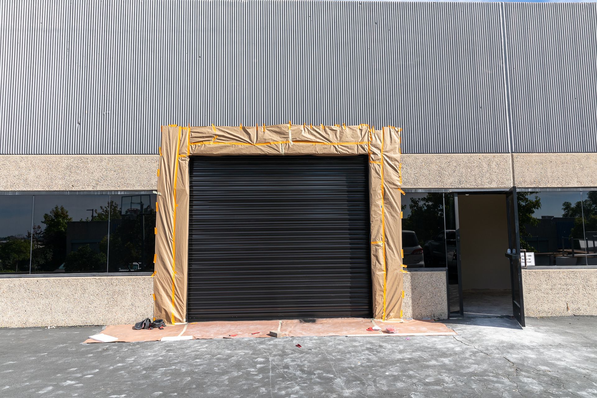 A building with a gray roof and a black garage door