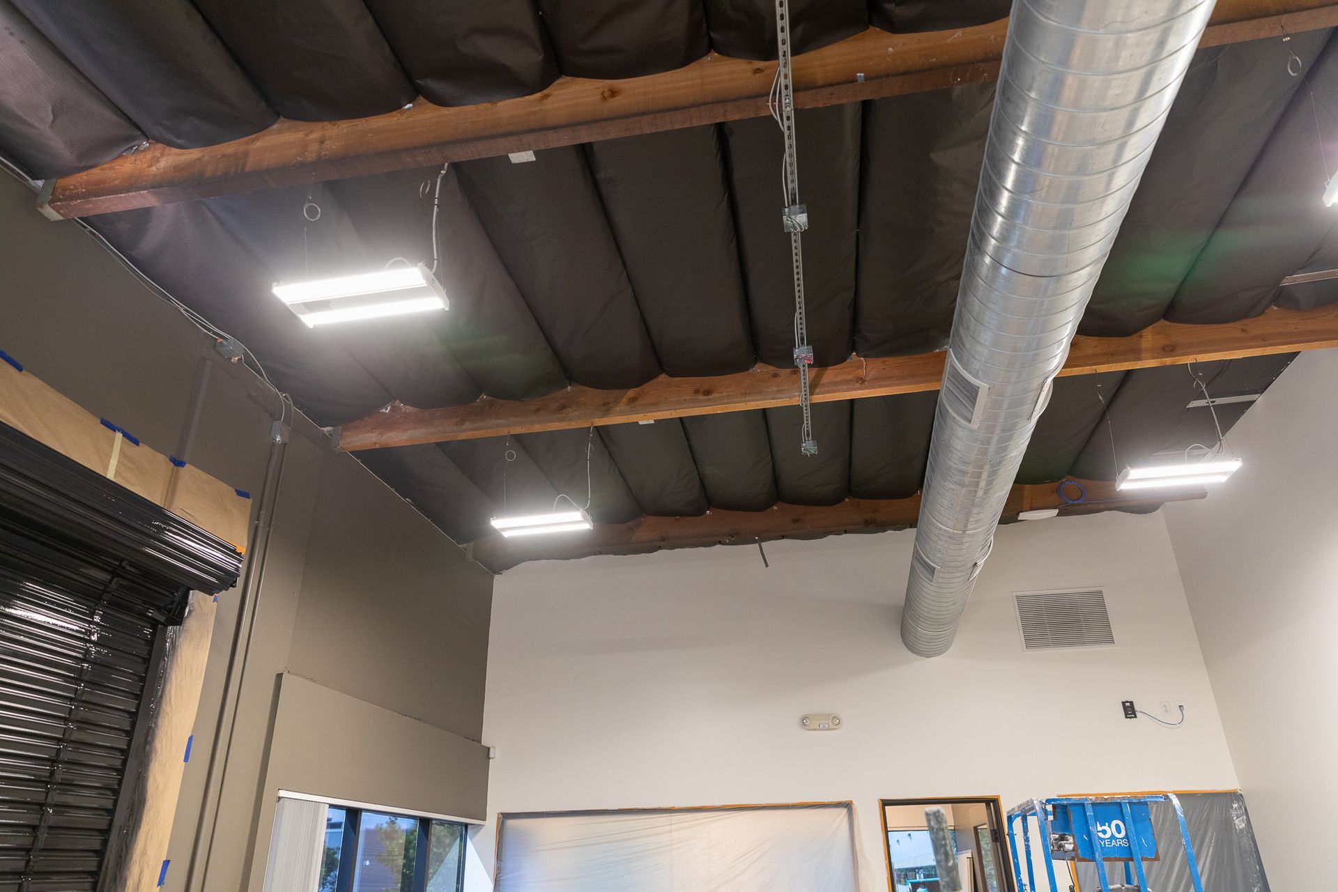 A room with a ceiling that has a lot of pipes hanging from it.