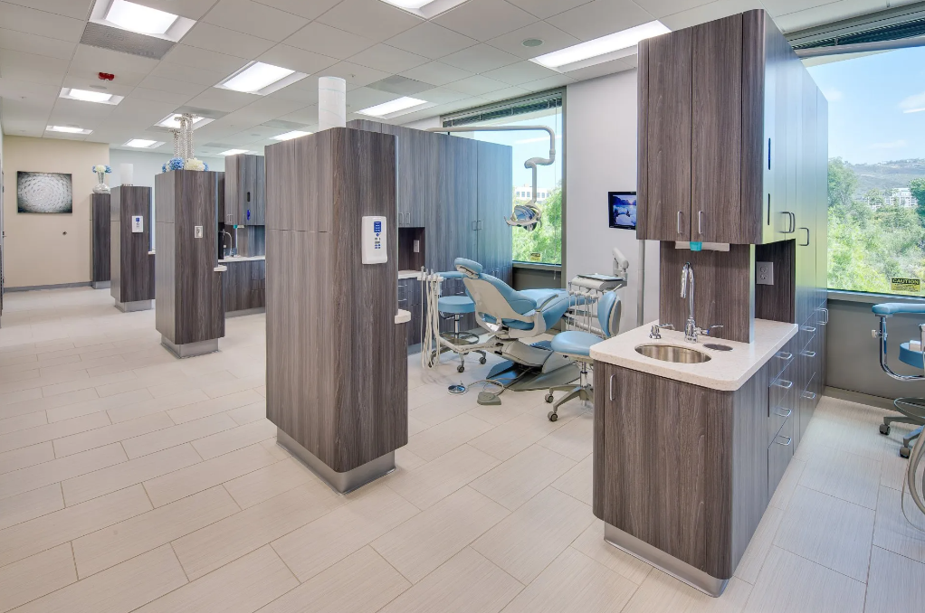 A dental office with a lot of cabinets and a dental chair.