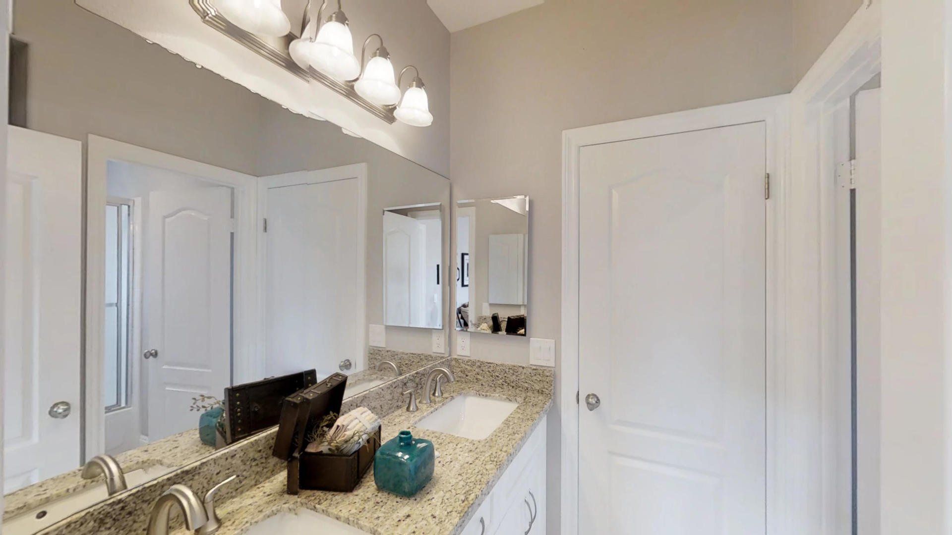 A bathroom with two sinks and a large mirror.