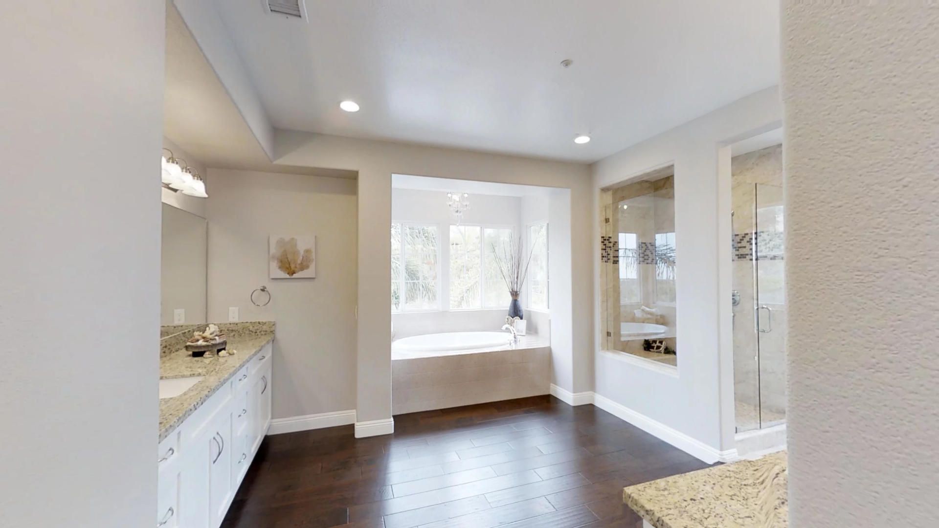A bathroom with two sinks , a tub and a shower.