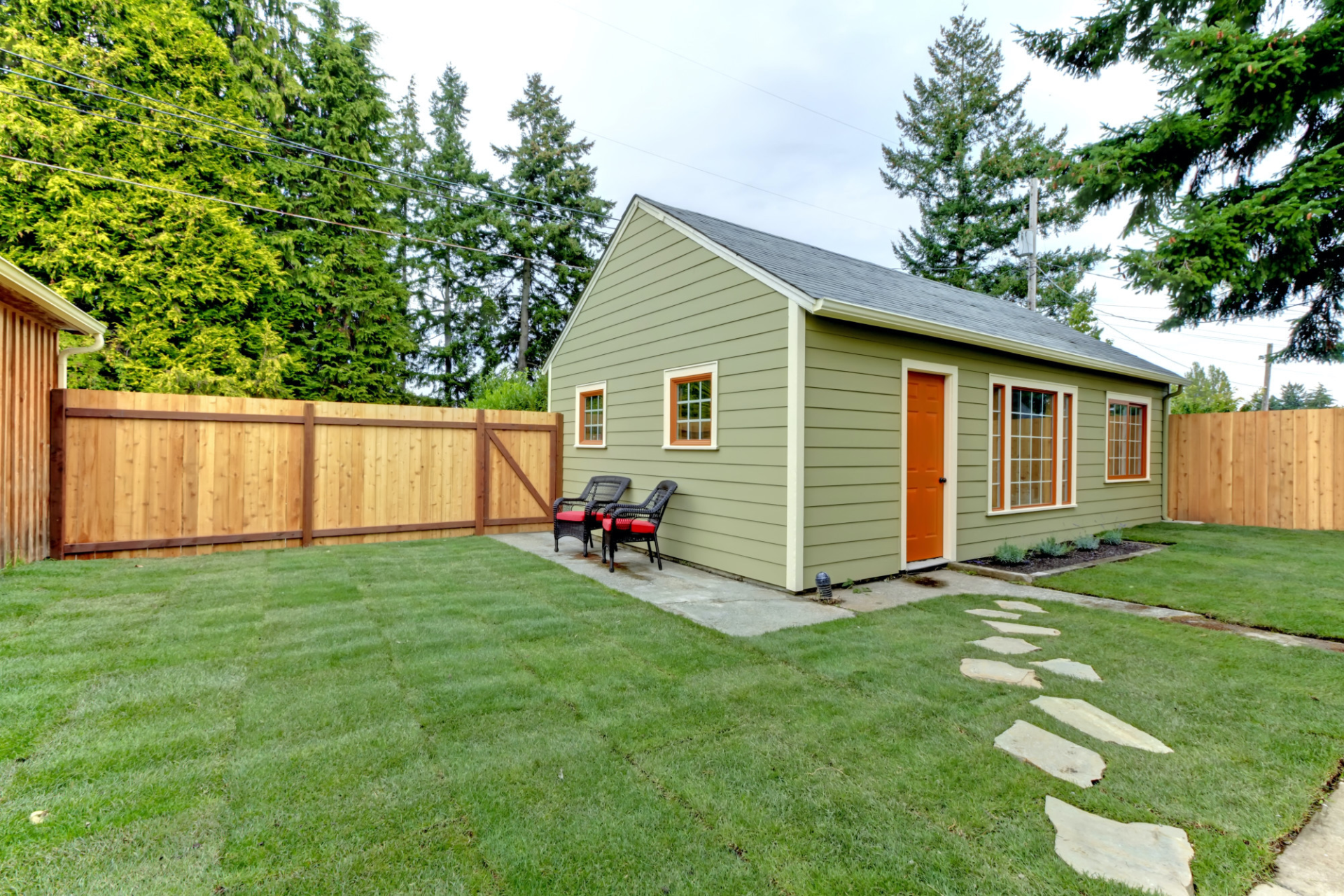 A small house with a wooden fence in the backyard