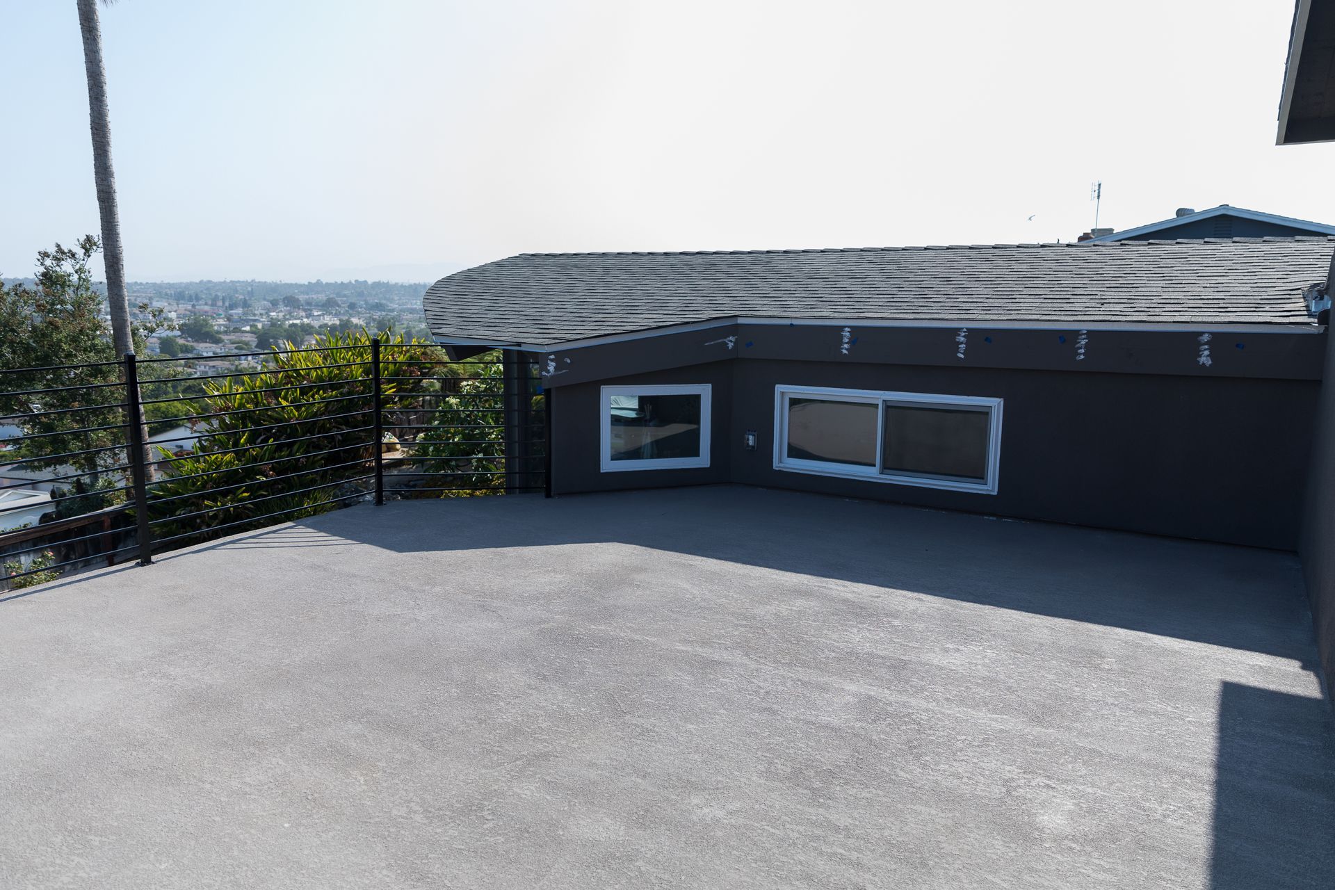 A large house with a lot of windows is sitting on top of a hill.