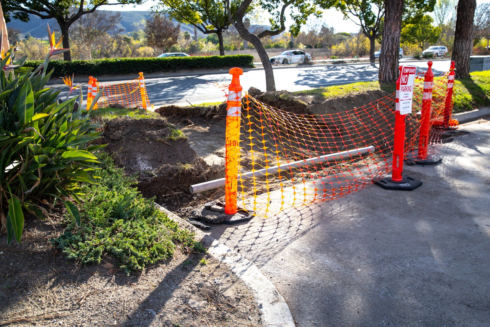 A fence surrounds a hole in the ground that is being worked on