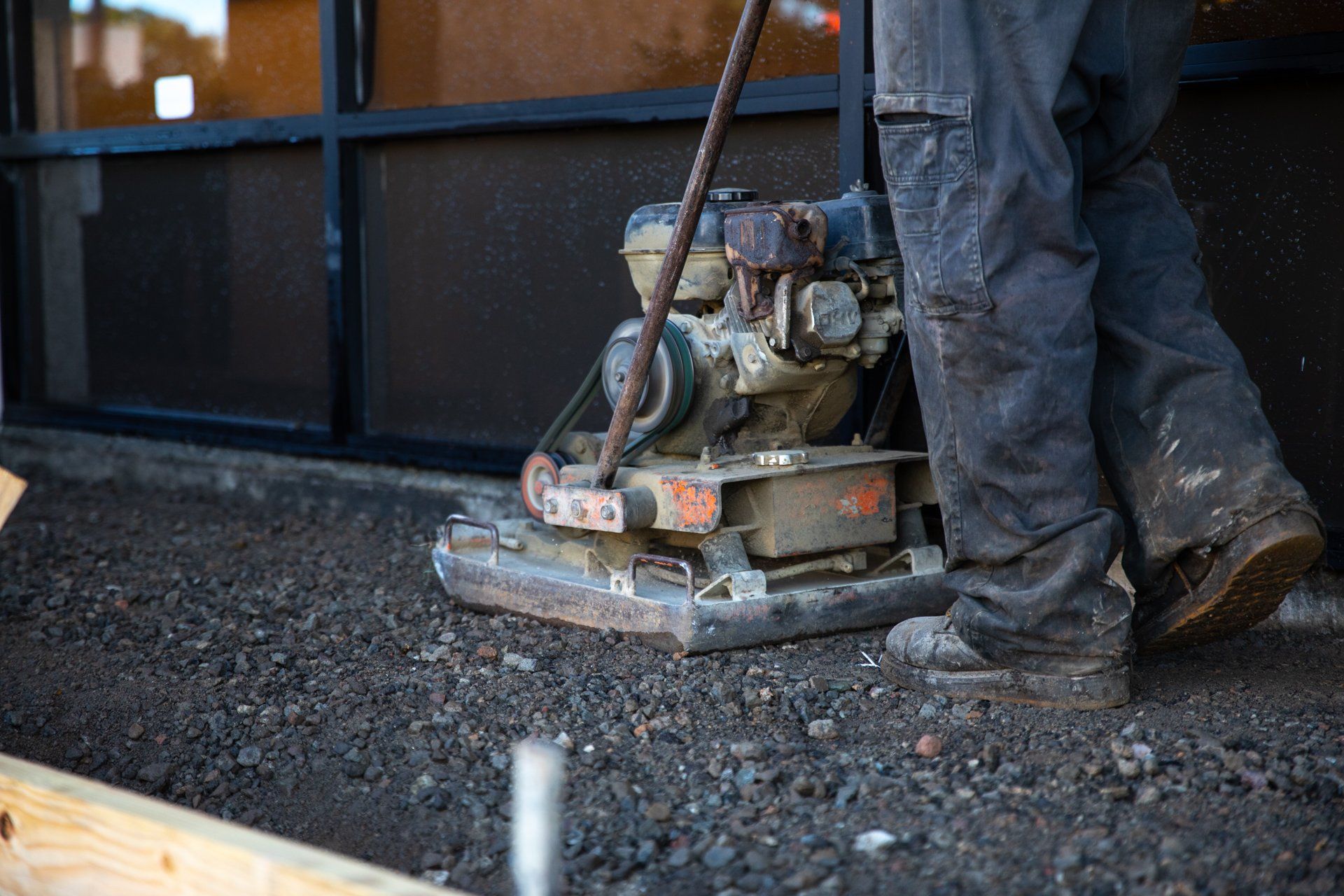 A construction worker is using a machine that says ' bosch ' on it