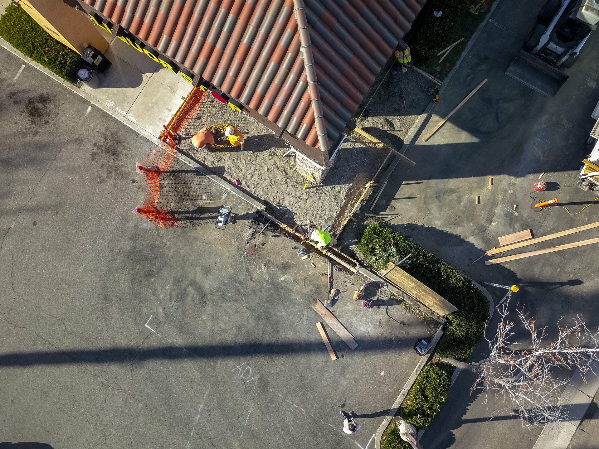 An aerial view of a construction site with a building in the background