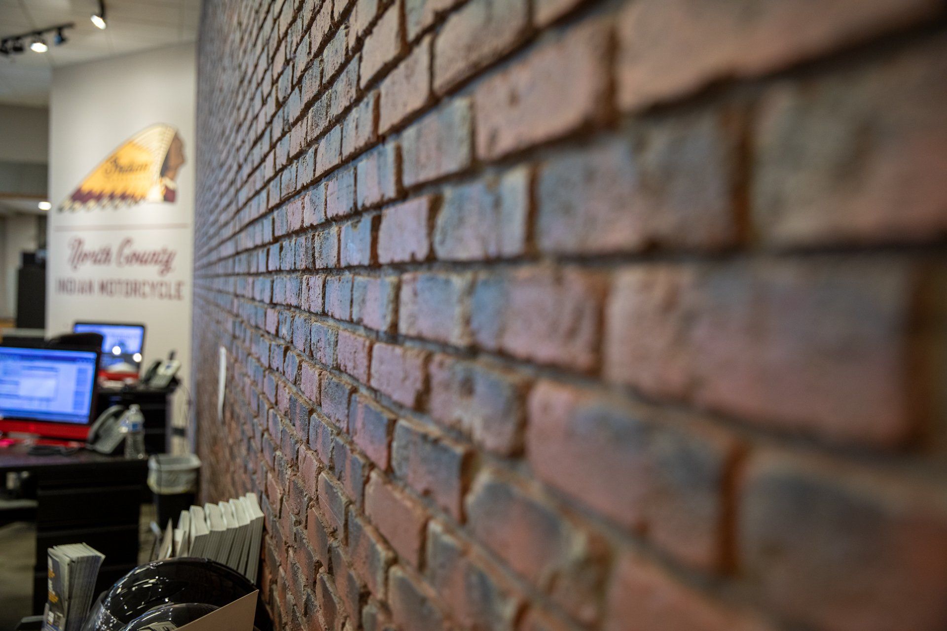 A brick wall in a room with a computer on it.