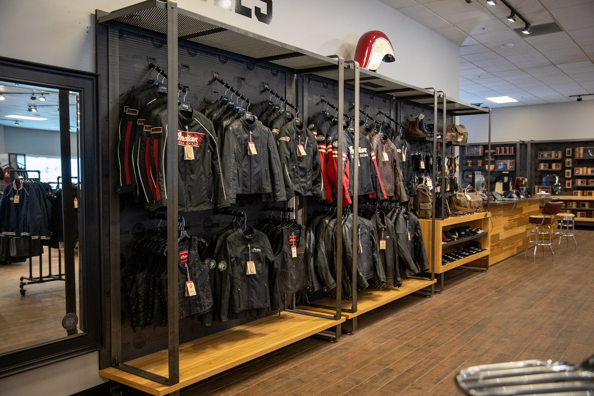 A motorcycle shop filled with lots of jackets and helmets.