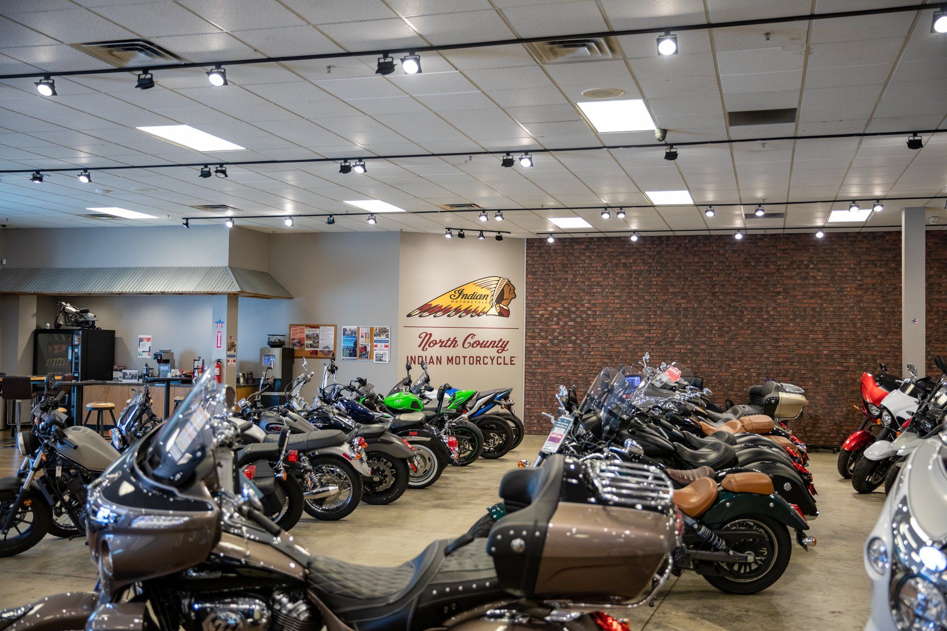 A lot of motorcycles are parked in a showroom.