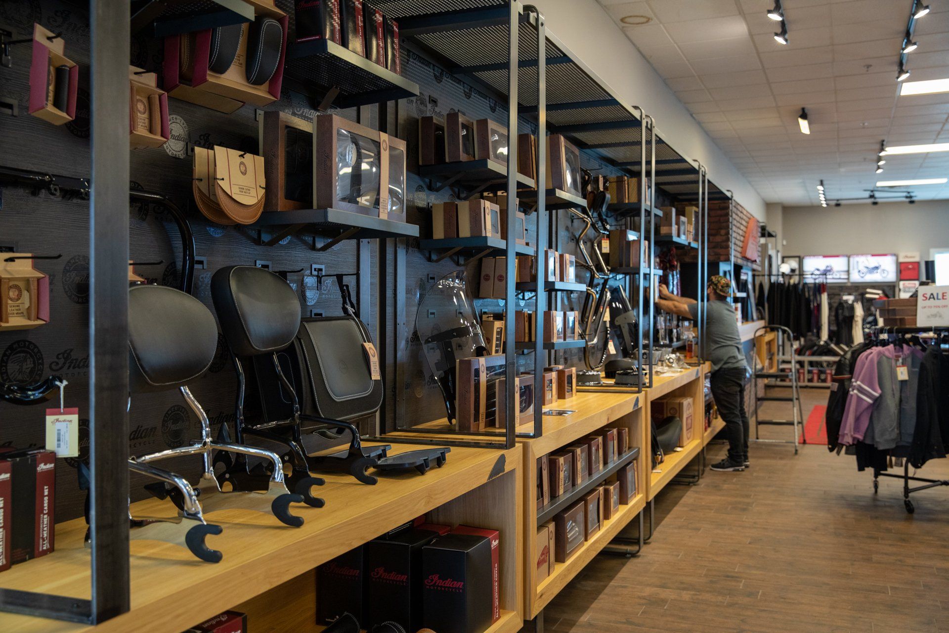 A man is standing in a store with a lot of shelves and chairs.