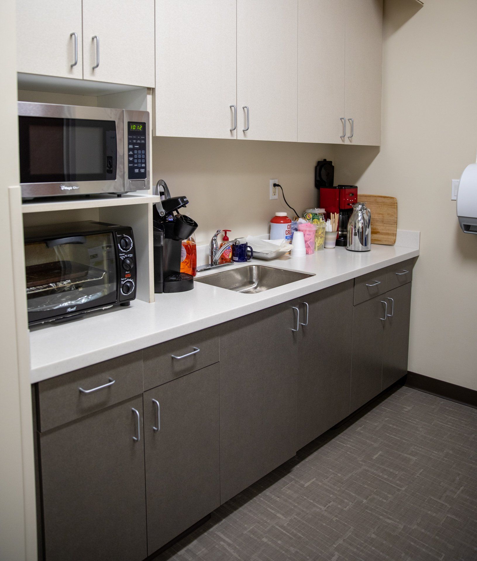 A kitchen with a sink a microwave and a toaster oven