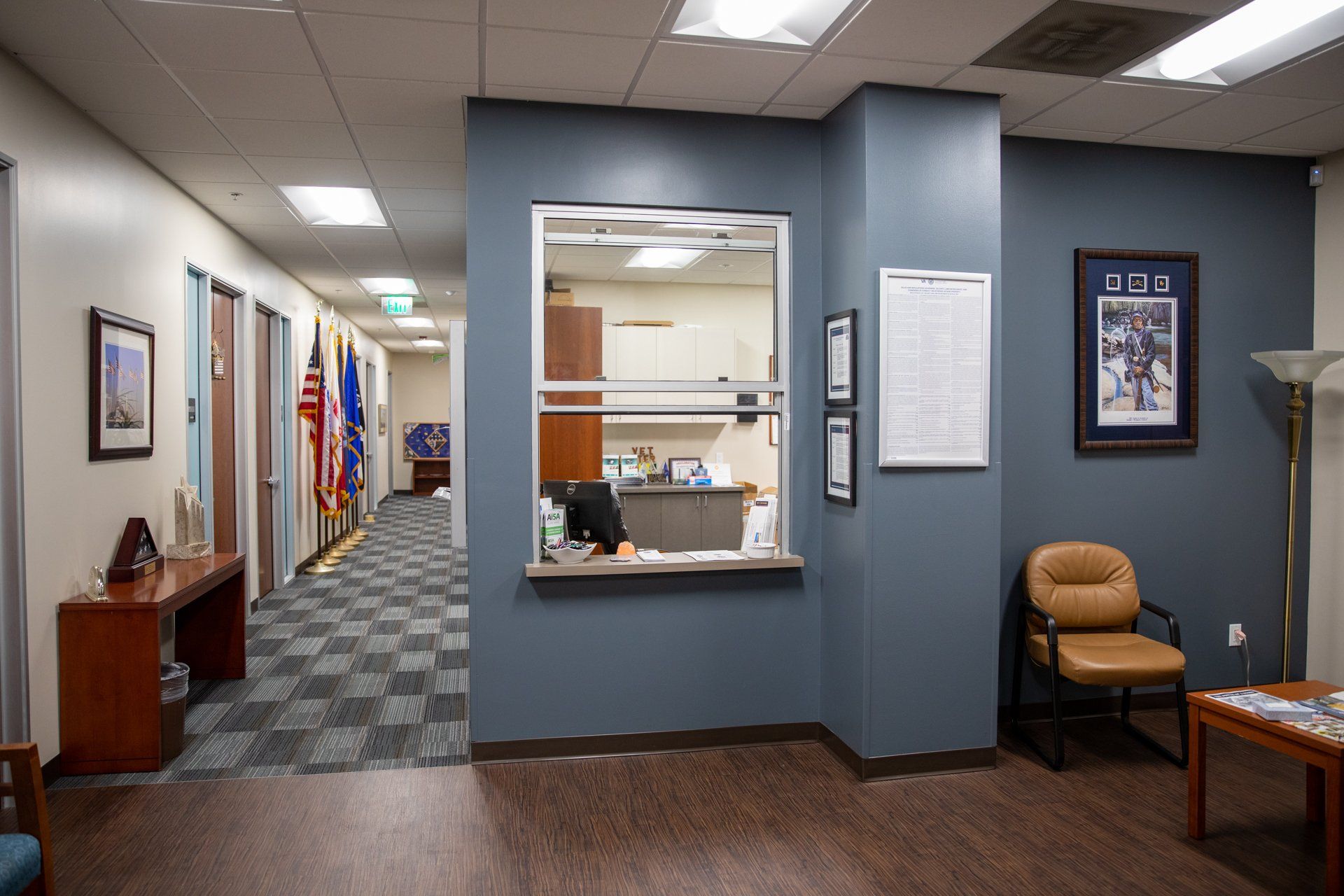 A waiting room with a desk and chairs and a window