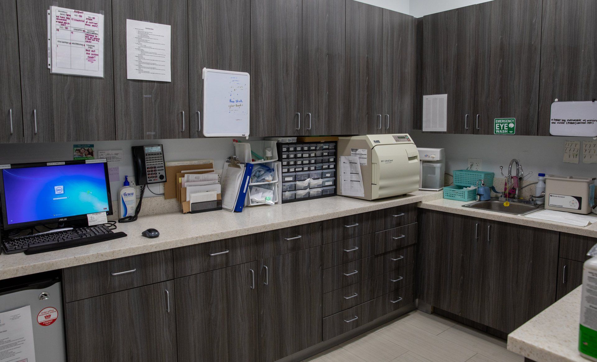 There is a computer on the counter in the kitchen.