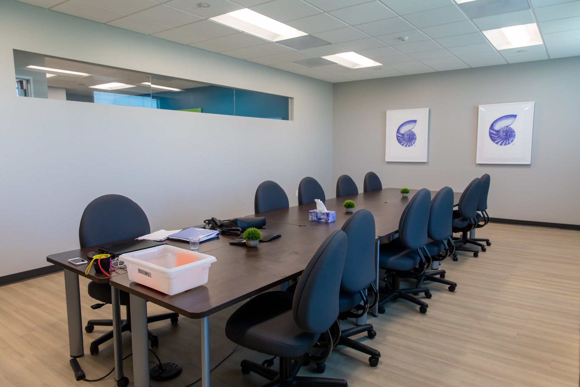 A conference room with a long table and chairs.