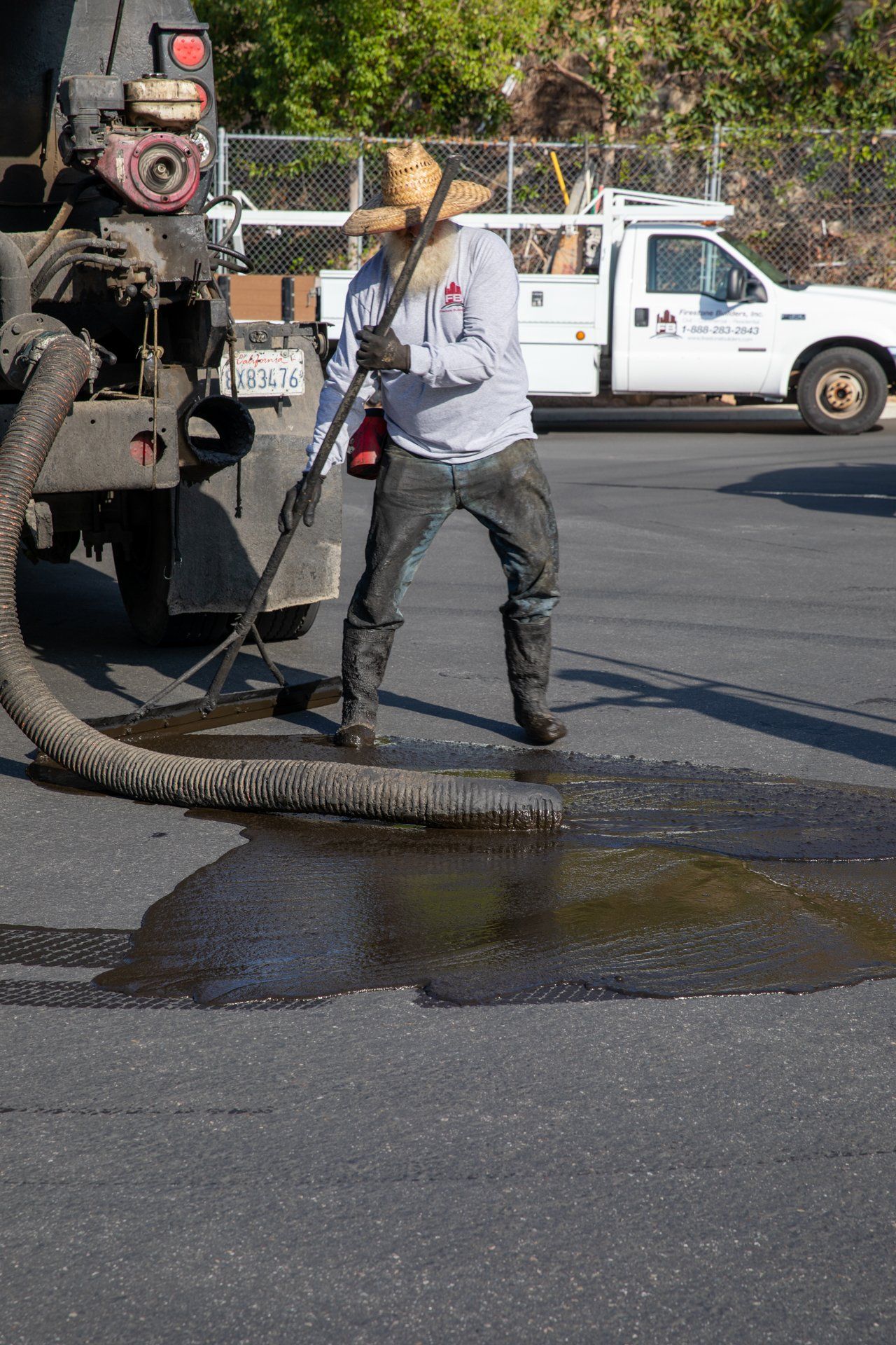 A man is standing in a puddle of water next to a truck.