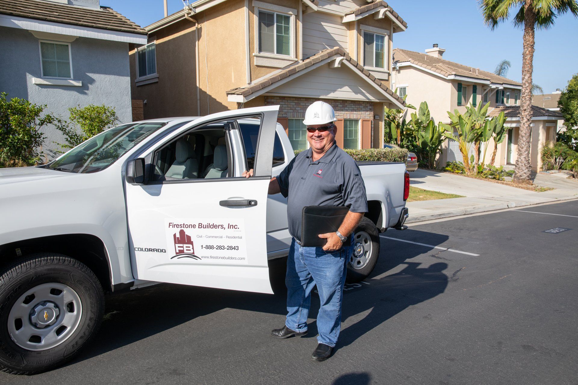 A man standing in front of a white truck that says ' california ' on the side