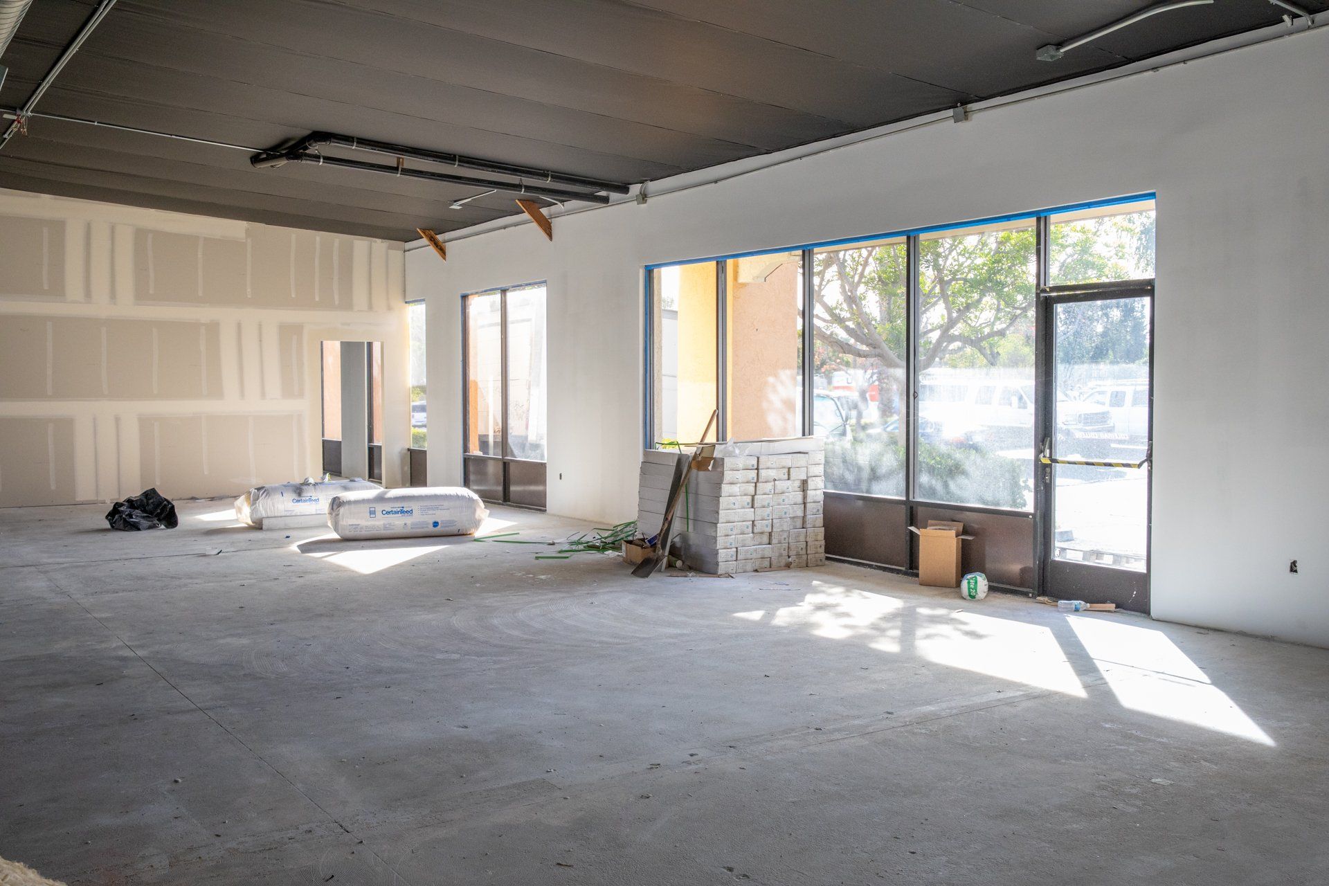 An empty room with a lot of windows and a door.