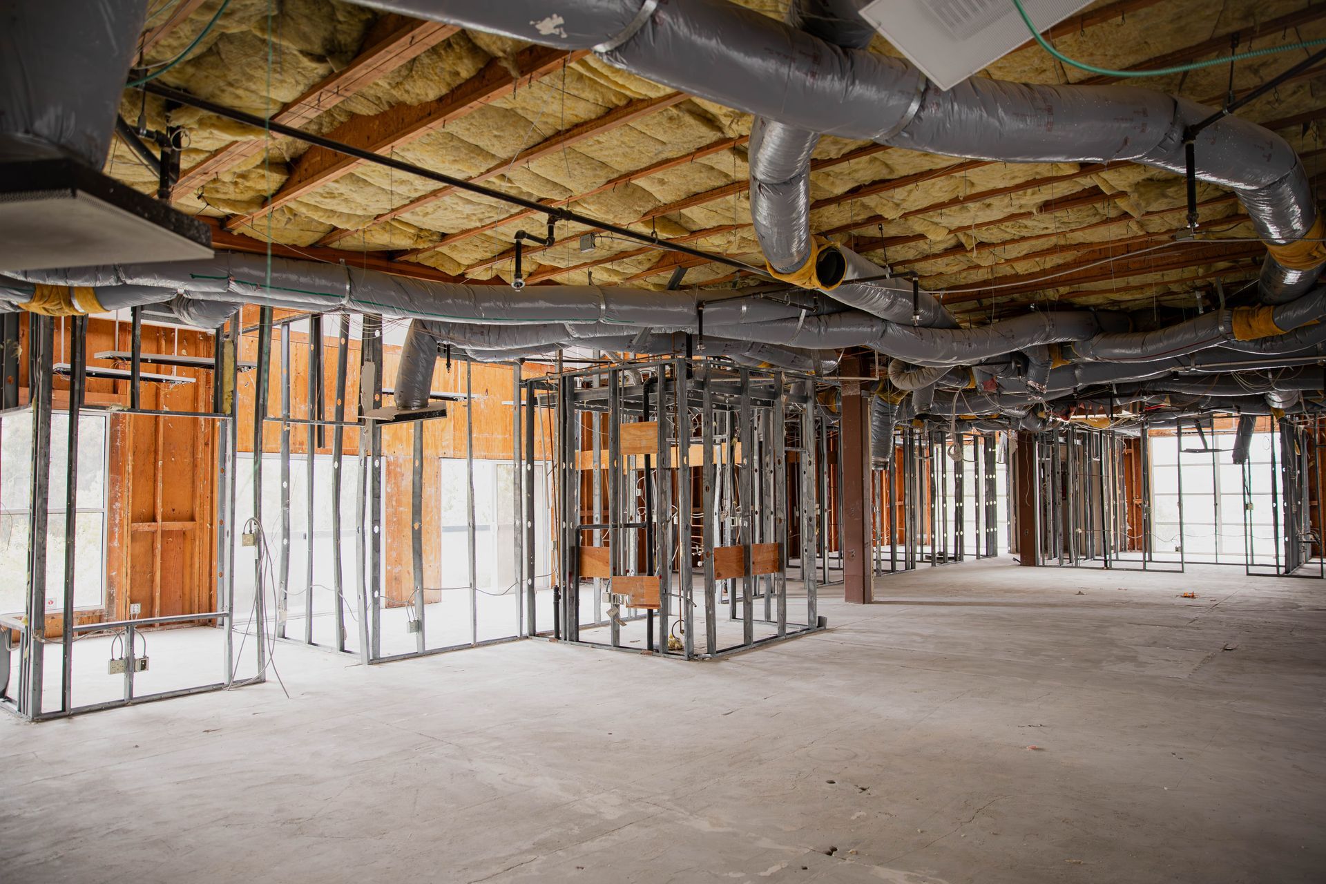 A large empty room with a lot of pipes coming out of the ceiling.