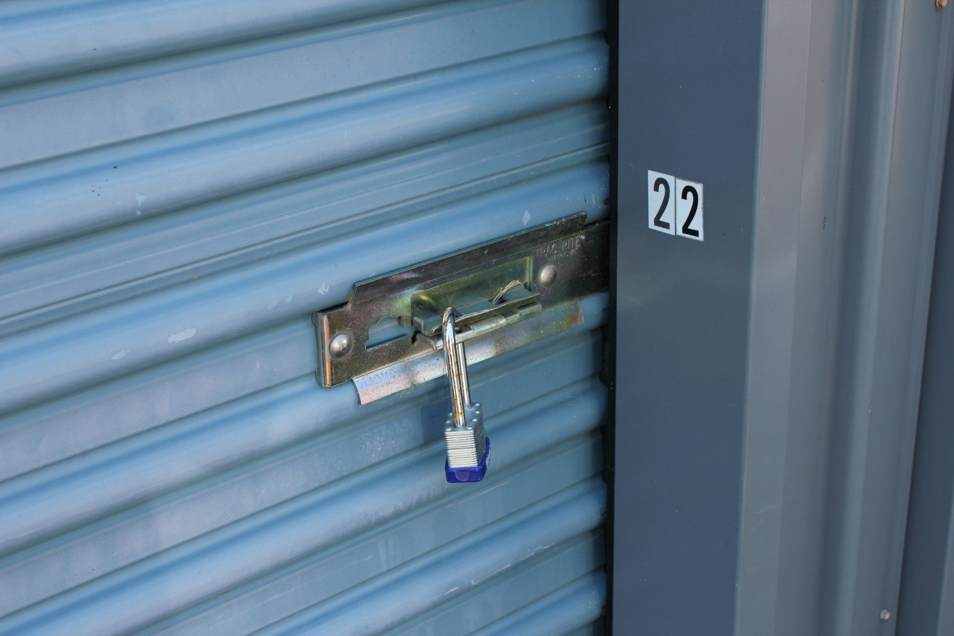 Blue storage unit door with a locked latch; the number 22 is visible.