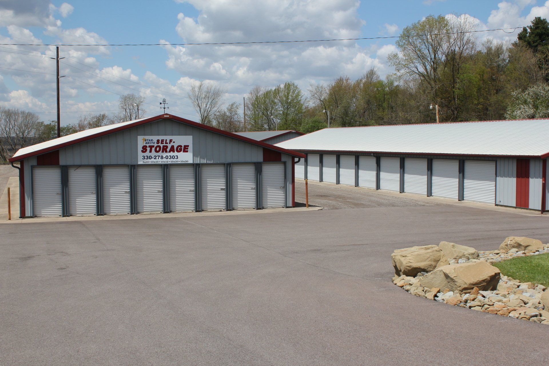 Storage units with red trim under a blue sky.