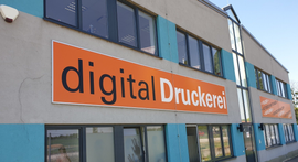 Ein Gebäude mit einem Schild mit der Aufschrift „Digitaldruckerei“.