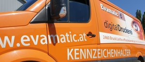 Ein orangefarbener Transporter mit der Website www.evamatic.at an der Seite