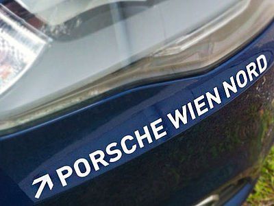 Eine Nahaufnahme eines Porsche Wien Nord-Autoaufklebers auf einem Auto.