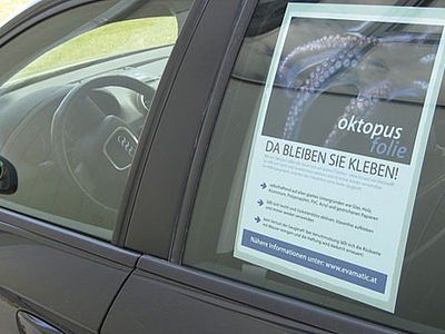 Ein Auto mit einem Poster am Fenster, auf dem „Octopus Folie“ steht