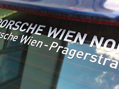 Eine Nahaufnahme eines Porsche-Wien-Aufklebers auf einem Autofenster