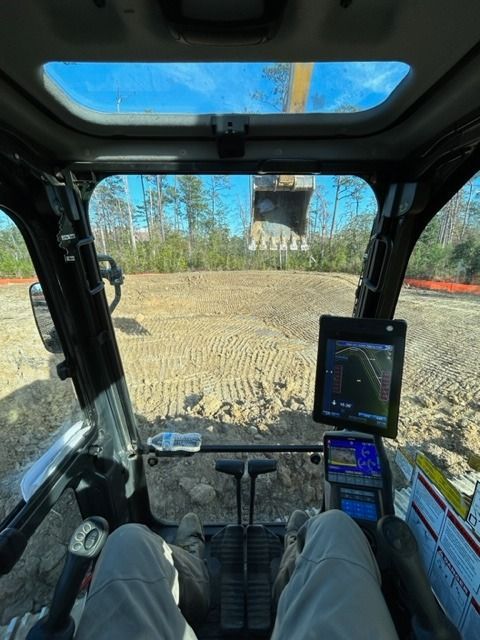 A person is sitting in the cockpit of a bulldozer.