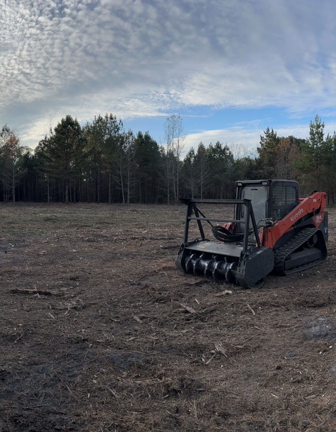 A construction worker is standing in front of a building under construction.