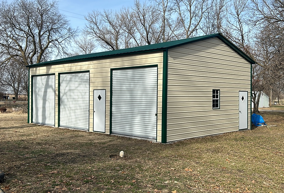 Tan metal garage with three garage doors and a green roof.
